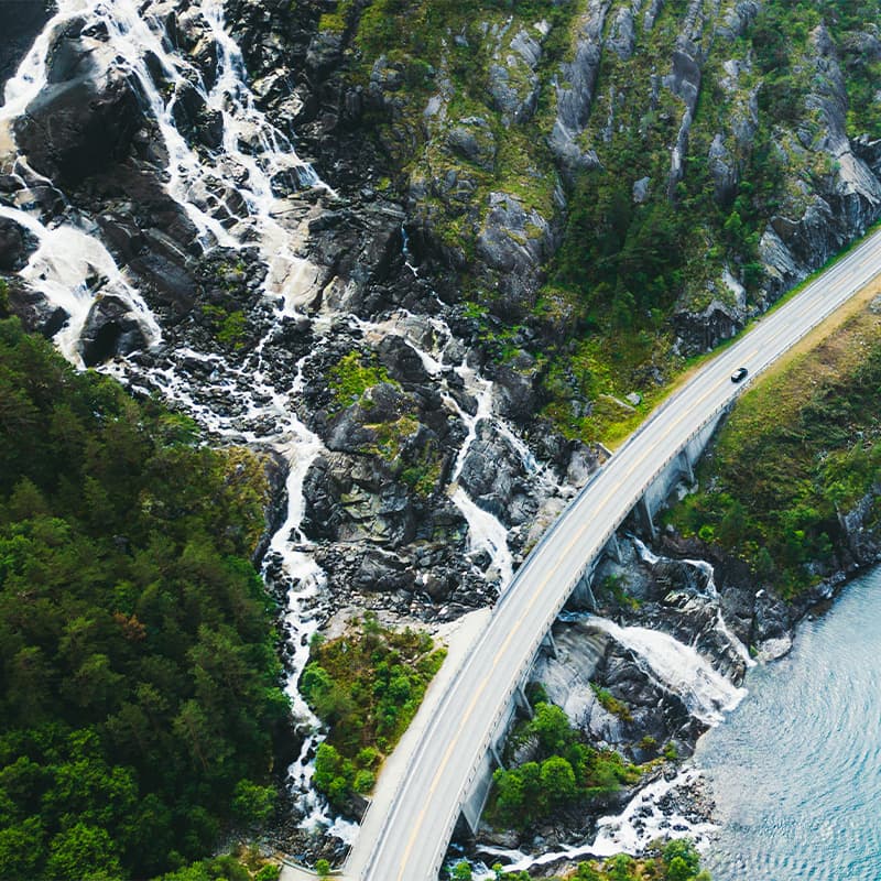 More to explore – Sustainability Car driving down a road next to the ocean