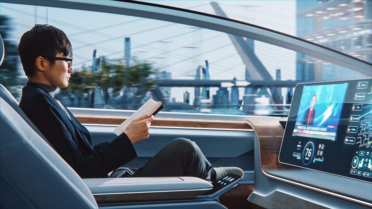 Passenger holding a book and watching the news in an autonomous car Passenger holding a book and watching the news in an autonomous car