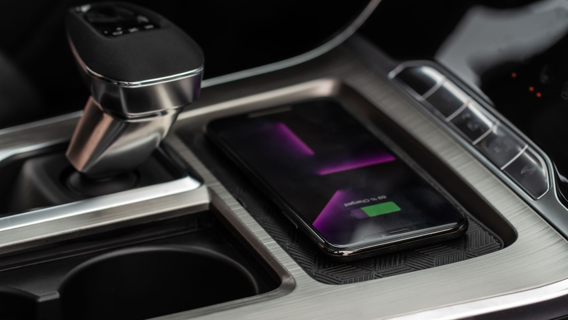 Phone charging while placed on a wireless phone charger module integrated into the central console of a car