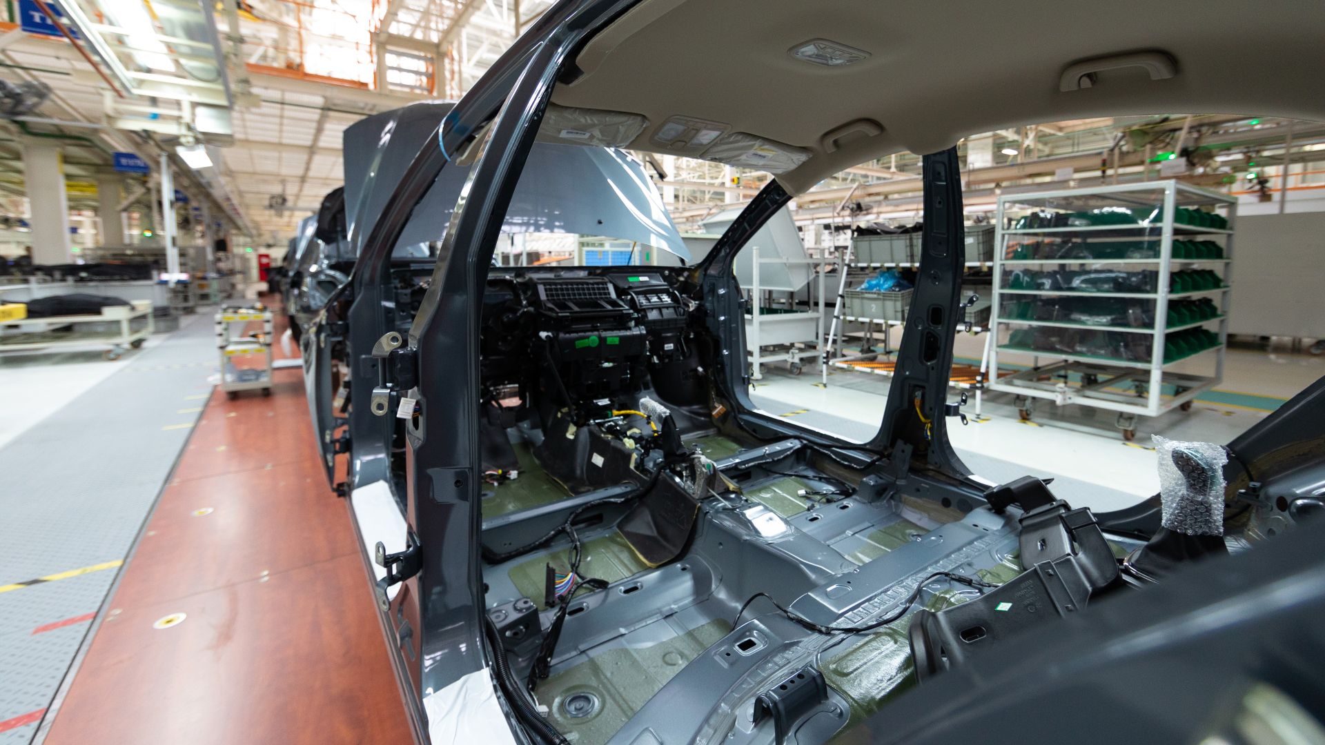 Close-up of a car chassis with wiring harnesses during the vehicle assembly process